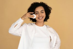 An image of a woman applying a face mask