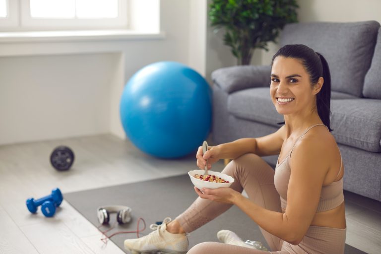 Happy young woman enjoys regular fitness exercise and well-balanced diet