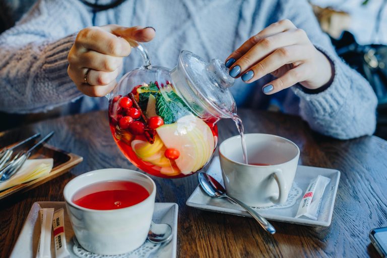 Woman-Filling-Tea-in-Cup-on-Table