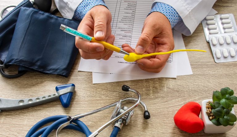 Doctor-during-consultation-held-in-his-hand-and-shows-patient-anatomical-model-of-male-sperm