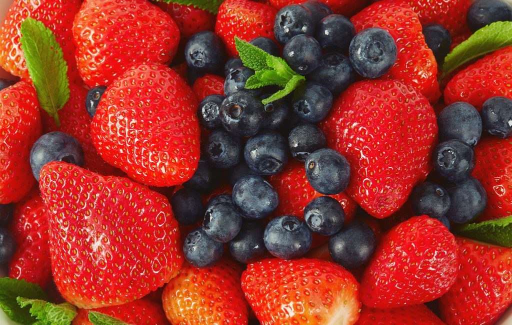 Strawberries and blueberries in a bowl isolated on white