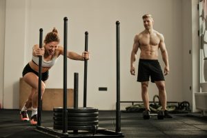 athletic-woman-making-effort-while-pushing-gym