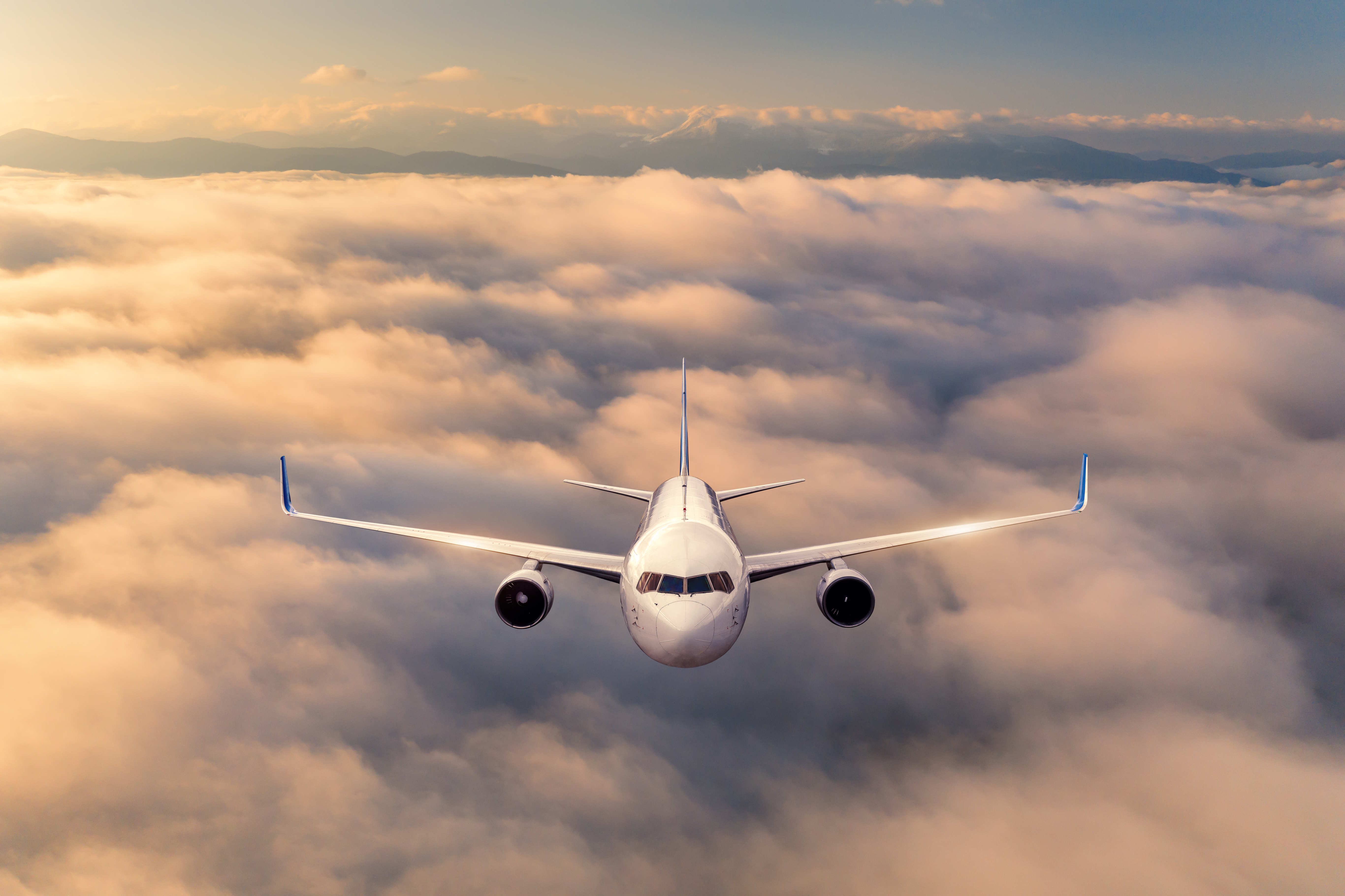 airplane-is-flying-above-the-clouds-at-sunrise