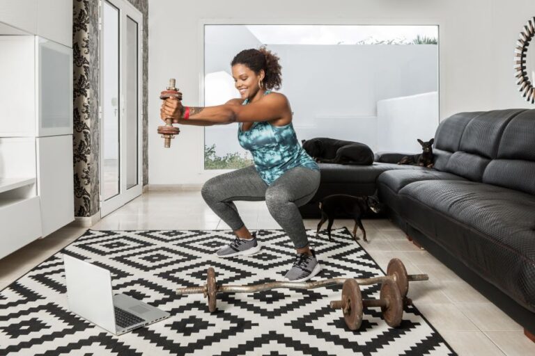 Black-sportswoman-doing-squats-with-dumbbell-at-home