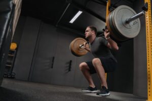 Muscular-sportsman-doing-back-squat-in-gym