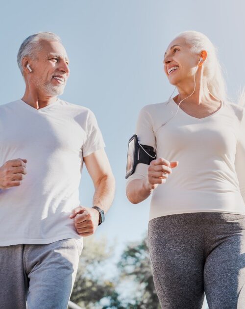 Close-up-of-healthy-smiling-mature-couple-jogging-in-the-city-at-early-morning