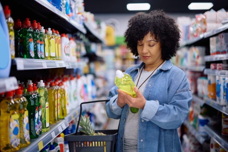 Mature woman reading label on a product while shopping in a supermarket.