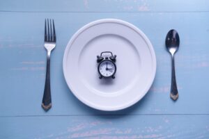 Dinner-Time-An-Alarm-Clock-Set-on-a-Plate-Surrounded-by-Various-Cutlery-Utensils