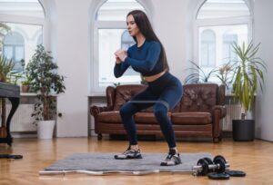 Concentrated-woman-does-yoga-with-resistance-band-in-apartment