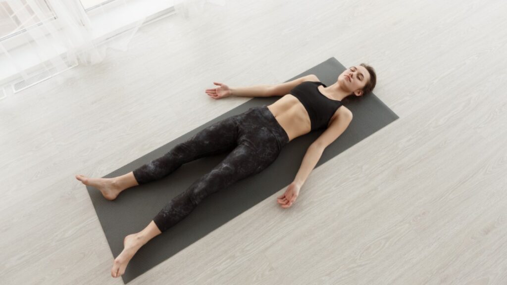 Young Woman Relaxing on Yoga Mat at Home