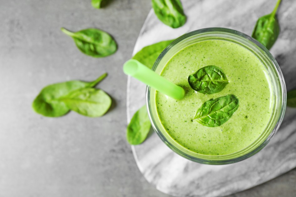 Flat lay composition with fresh green healthy spinach smoothie on grey table
