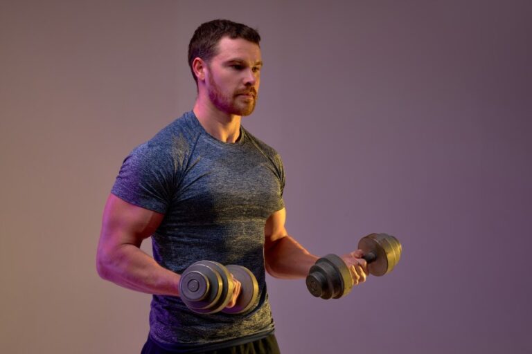 Man Working Out Lifting Dumbbells in Fitness Studio