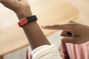 Person Touching Red and Black Fitness Tracker