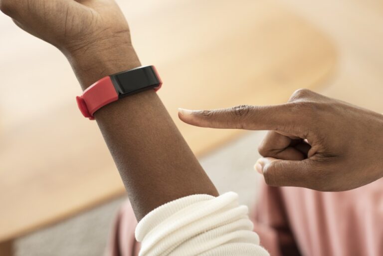 Person Touching Red and Black Fitness Tracker