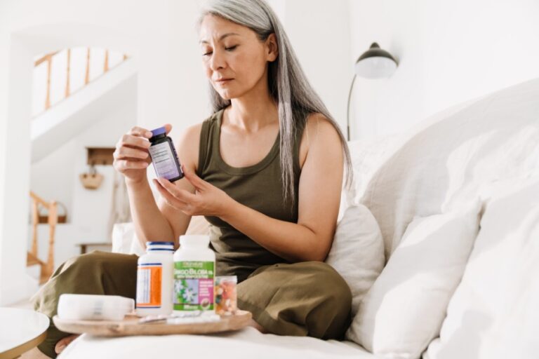 Woman Holding Supplement Bottle Indoors at Home