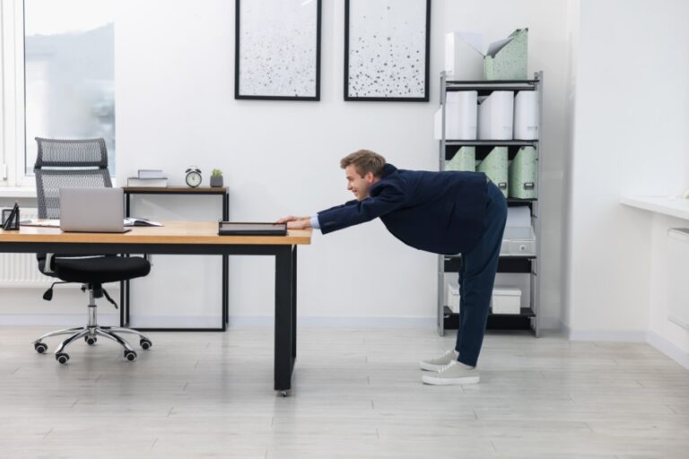 Young-businessman-doing-stretching-exercise-in-office