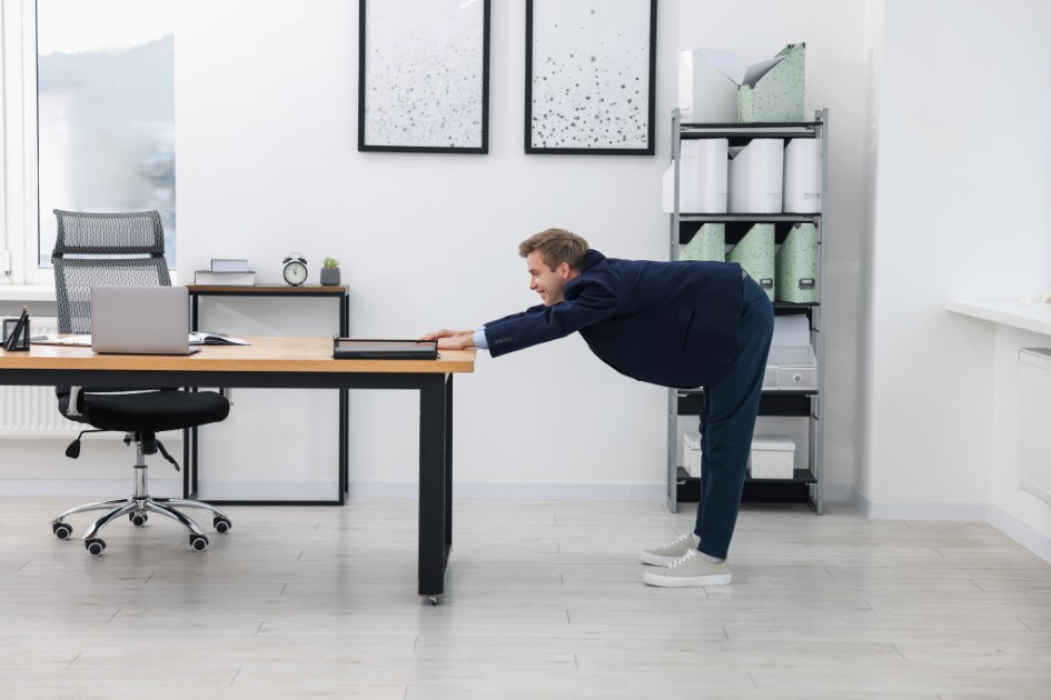 Young-businessman-doing-stretching-exercise-in-office