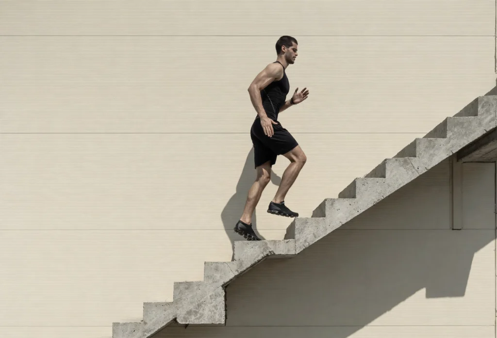 Adult in their 40s climbing office stairs at a fast pace